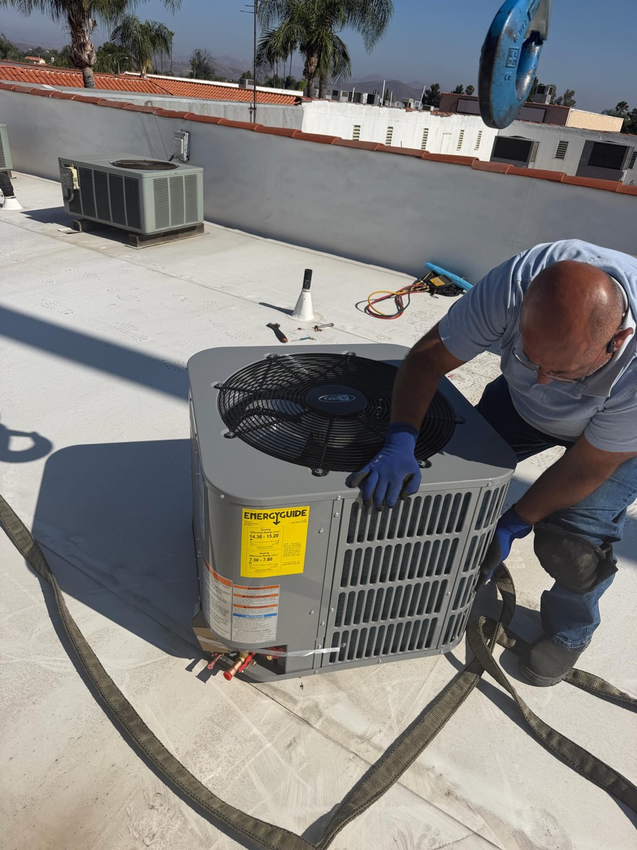 High Tech HVACR technician installing a new rooftop air conditioning unit in the valley